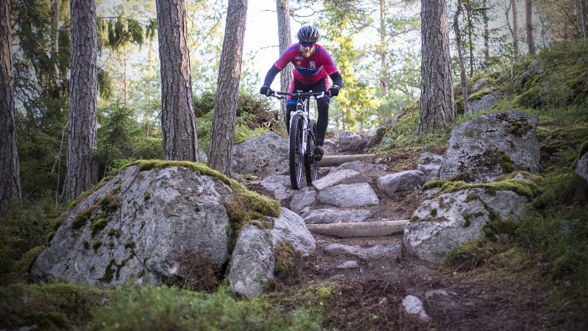Mies pyöräilee XCO-radalla.