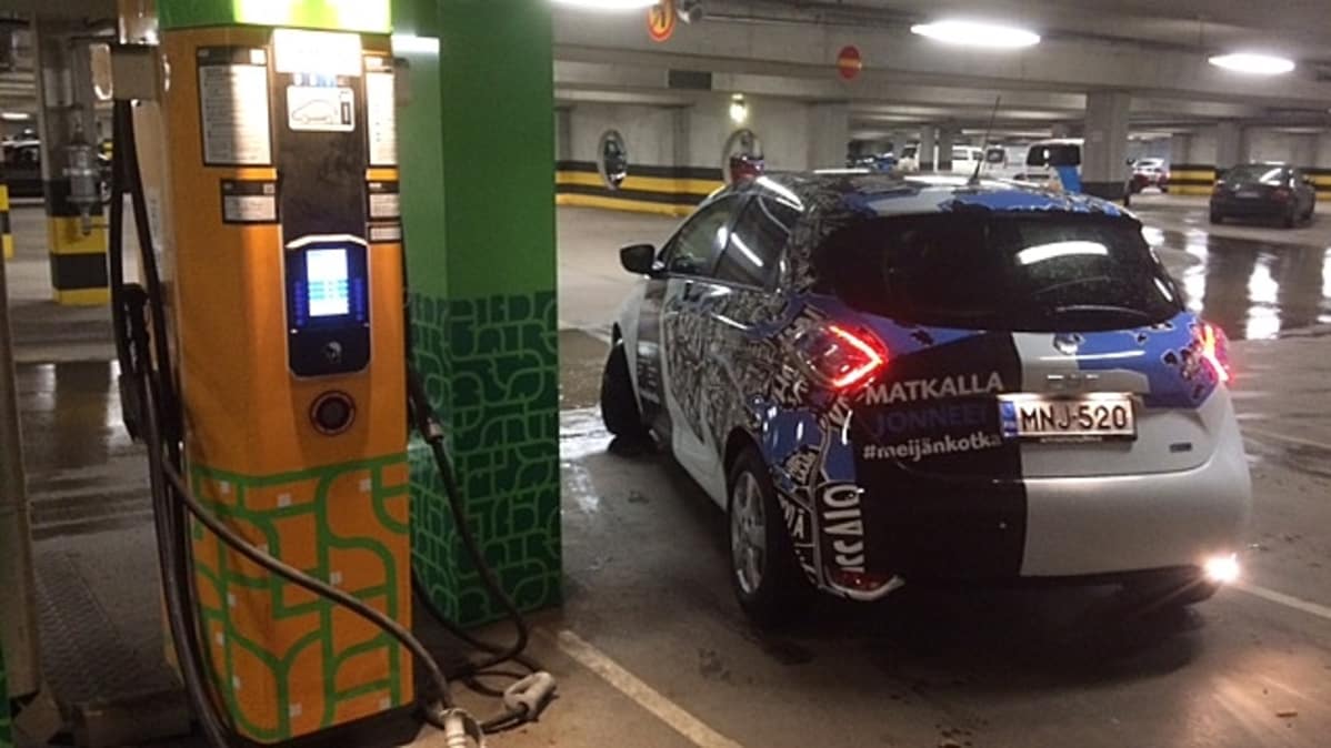 sähköauto lähtee liikkeelle latauspisteeltä parkkihallissa, Kotkan Toriparkki