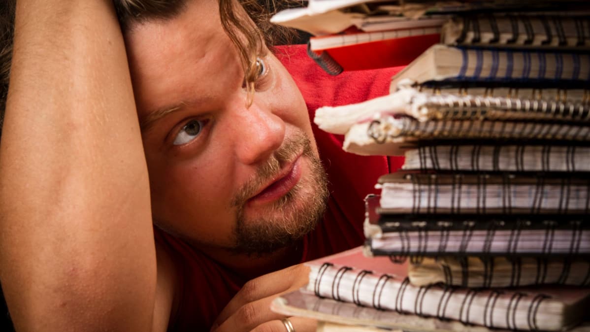 Ismo tallentaa komiikkaideoitaan kierrevihkoihin.