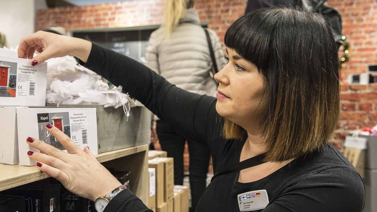 Perehdyttäjä Ona Vermilä laittaa tonttuovia hyllyyn Stockmannin tavaratalossa