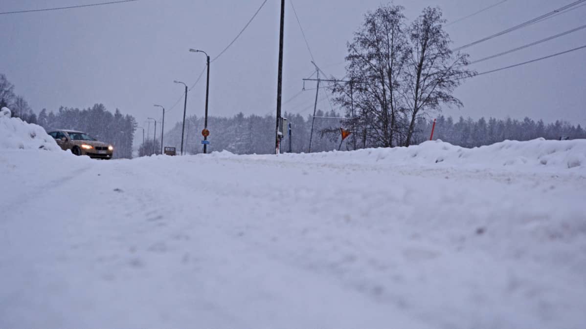 Auto kääntyy lumiselle tielle.