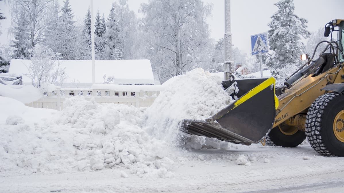 Kauhakuormaaja työntää lunta kadulla