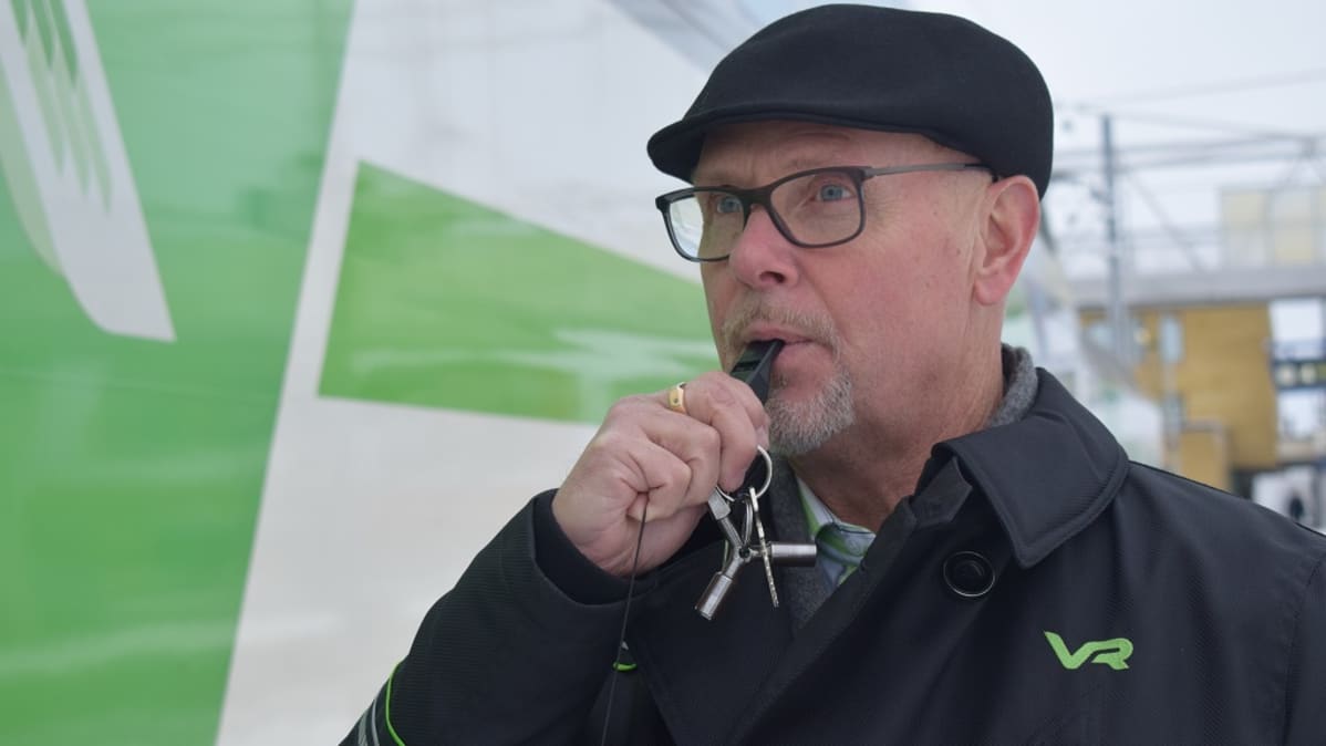 Konduktööri viheltää pilliin Turun päärautatieasemalla.