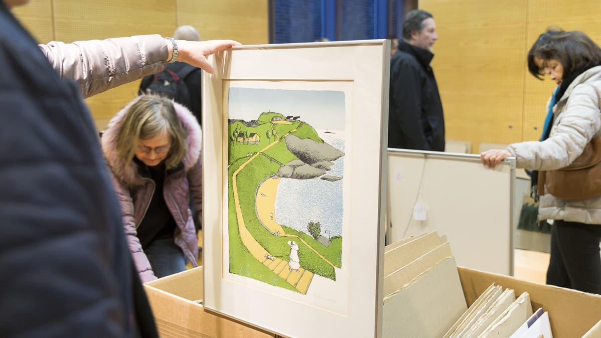 Yleisö katselee teoksia taidemyyntitapahtumassa.