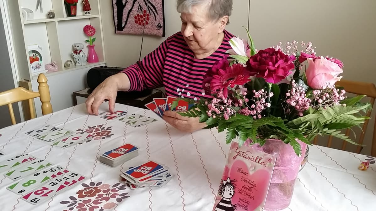 Aili Vuorio pelaa korttia.
