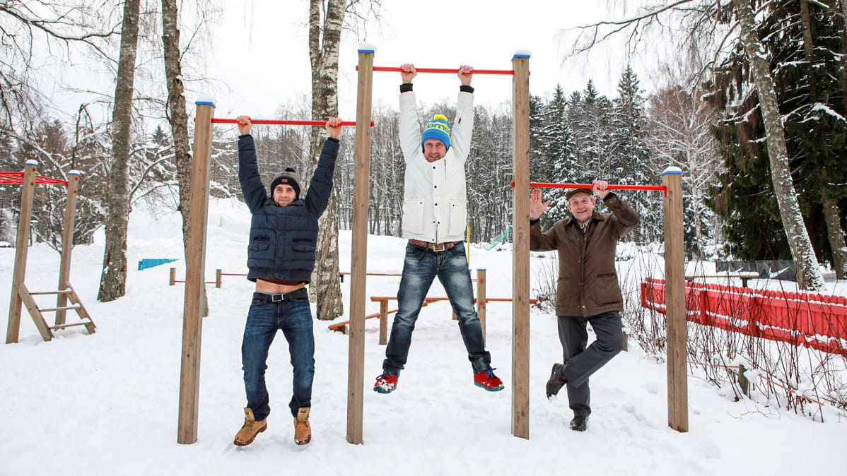 kolme miestä roikkuu rekillä