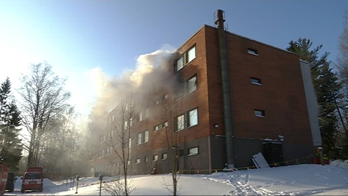 Savu tupruaa kerrostalon ikkunasta