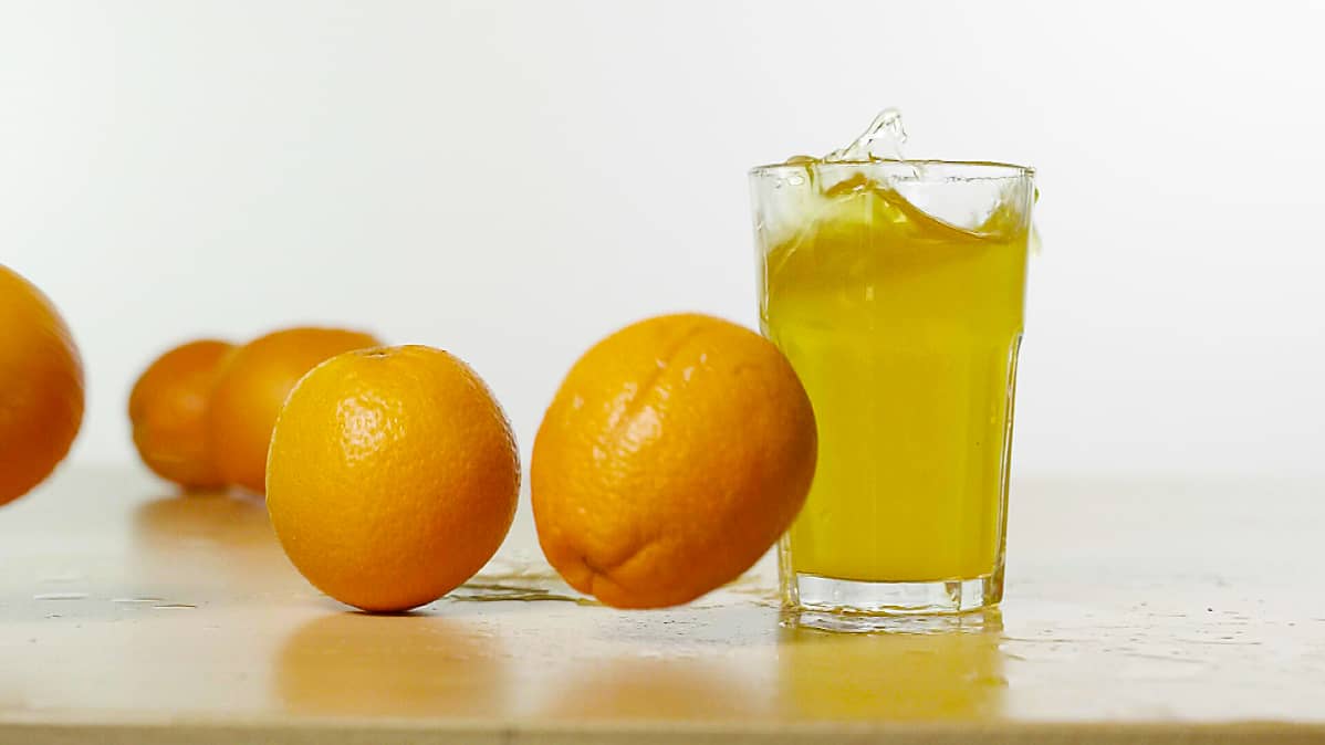 Appelsiineja ja juomalasi pöydällä.