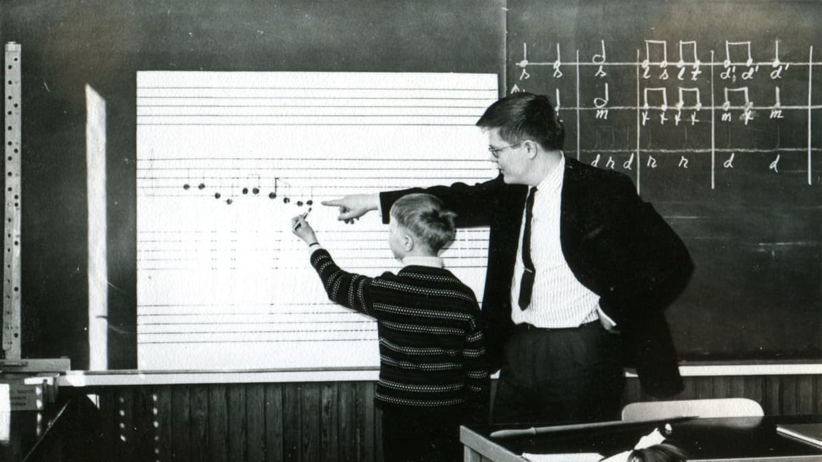 Musikkiluokkien perustaja Torsten Lindfors opettaa Juha Johanssonille nuottien saloja vuonna 1967.