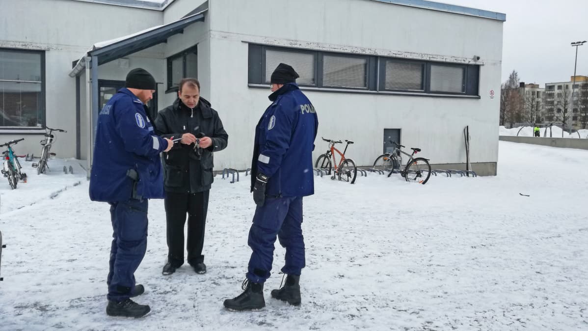 Pirkkalan koulukeskuksen vahtimestari Mertsi Grönfors antaa avaimet poliisille