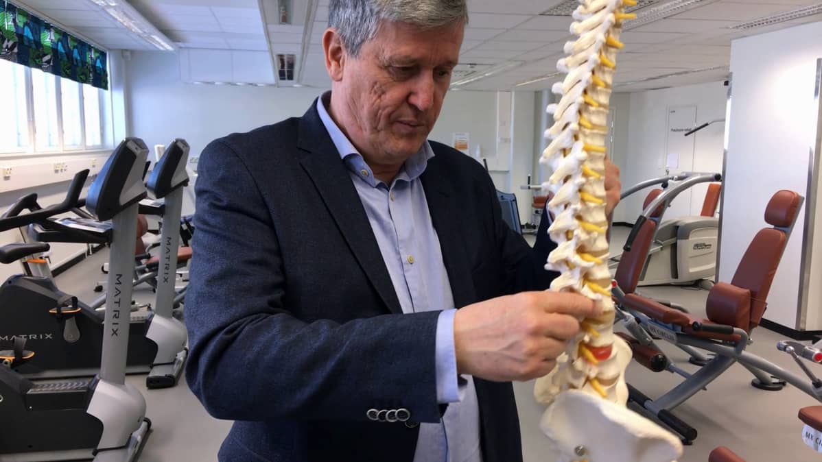 Professori Jaro Karppisen kädessä on malli selkärangasta