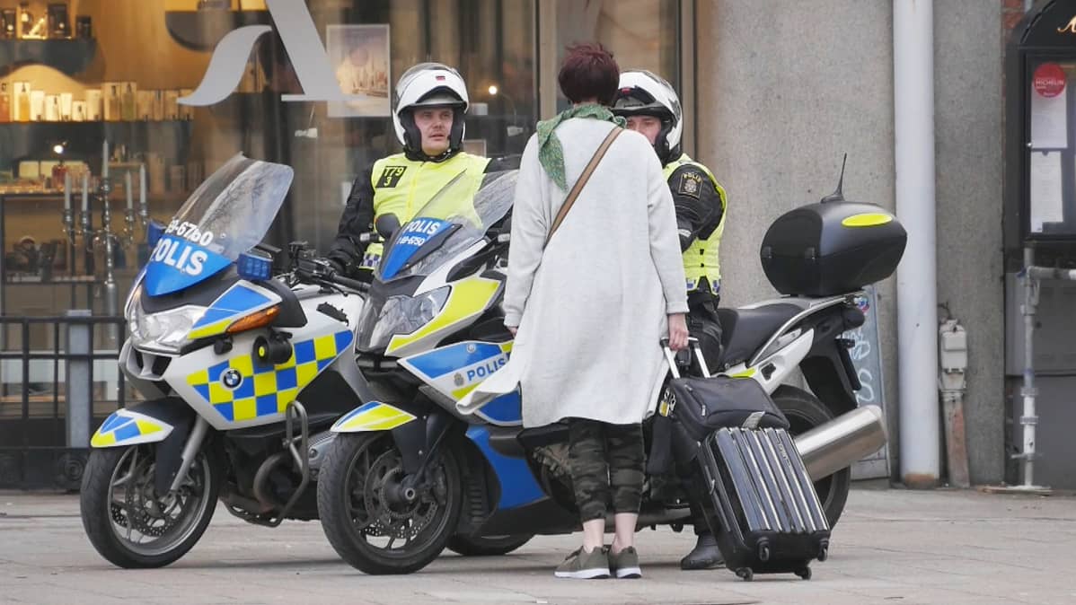 Nainen keskustelee moottoripyöräpoliisien kanssa.