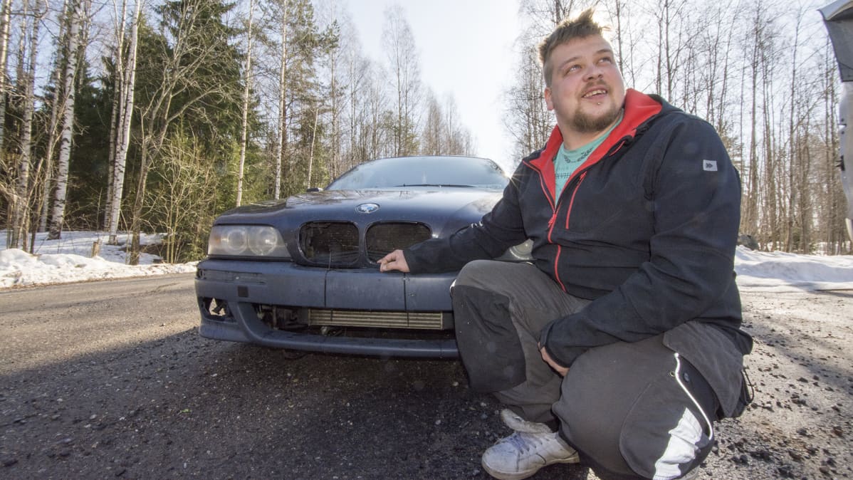 Mies auton edessä.