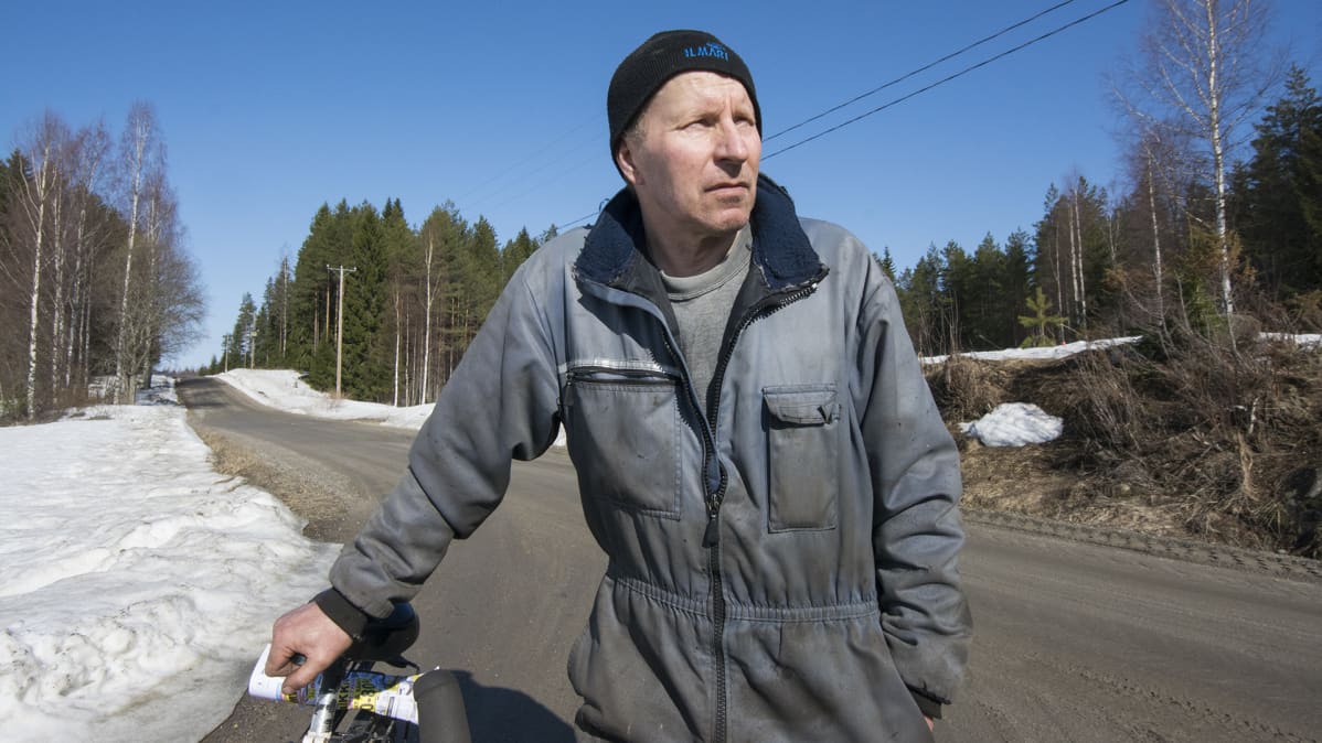Mies pyörän vierellä.
