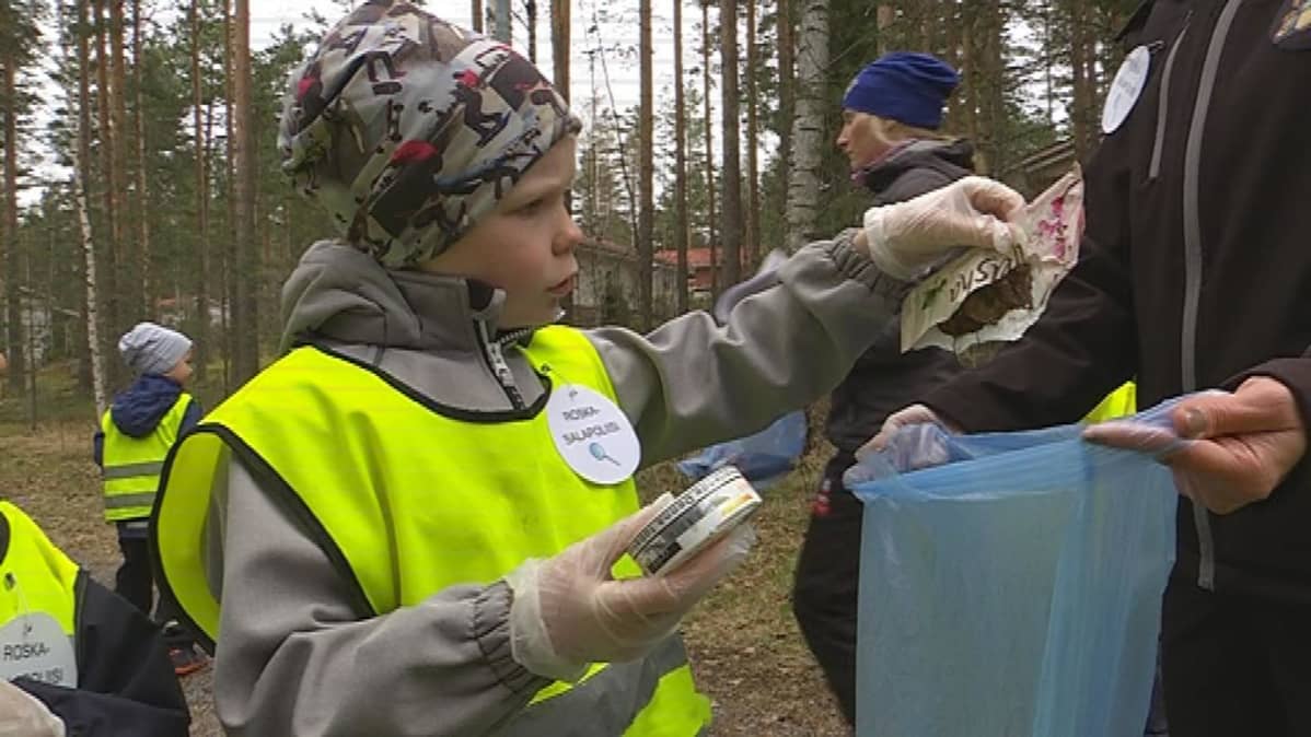 Ville laittaa roskia pussiin.