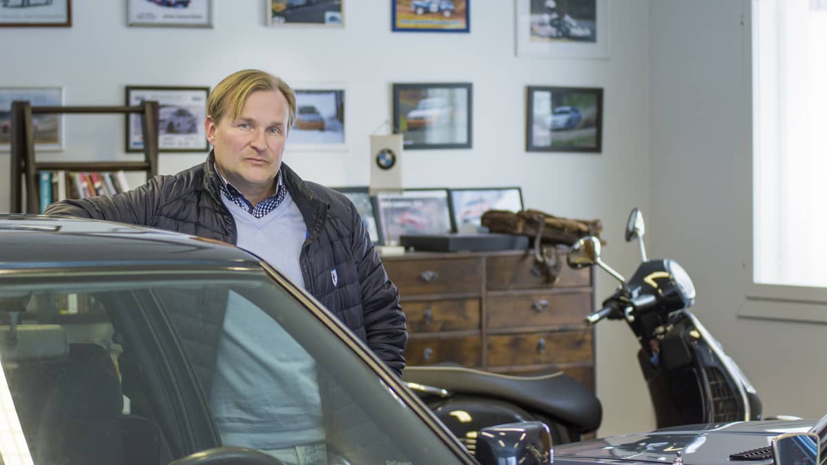 Mies seisoo autonsa edessä