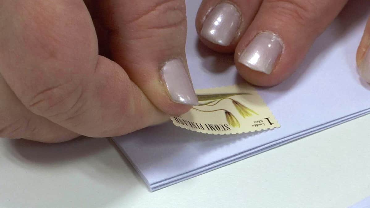 Postimerkki liimataan kirjekuoreen.