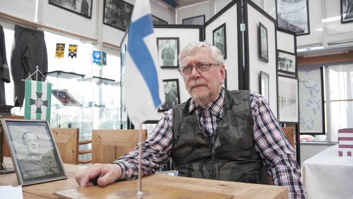 Mies istuu pöydän ääressä