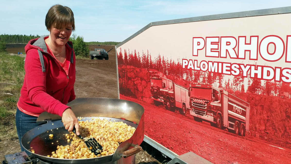 Marianne Ukskoski paistaa pyttipannua turvepalon sammuttajille.