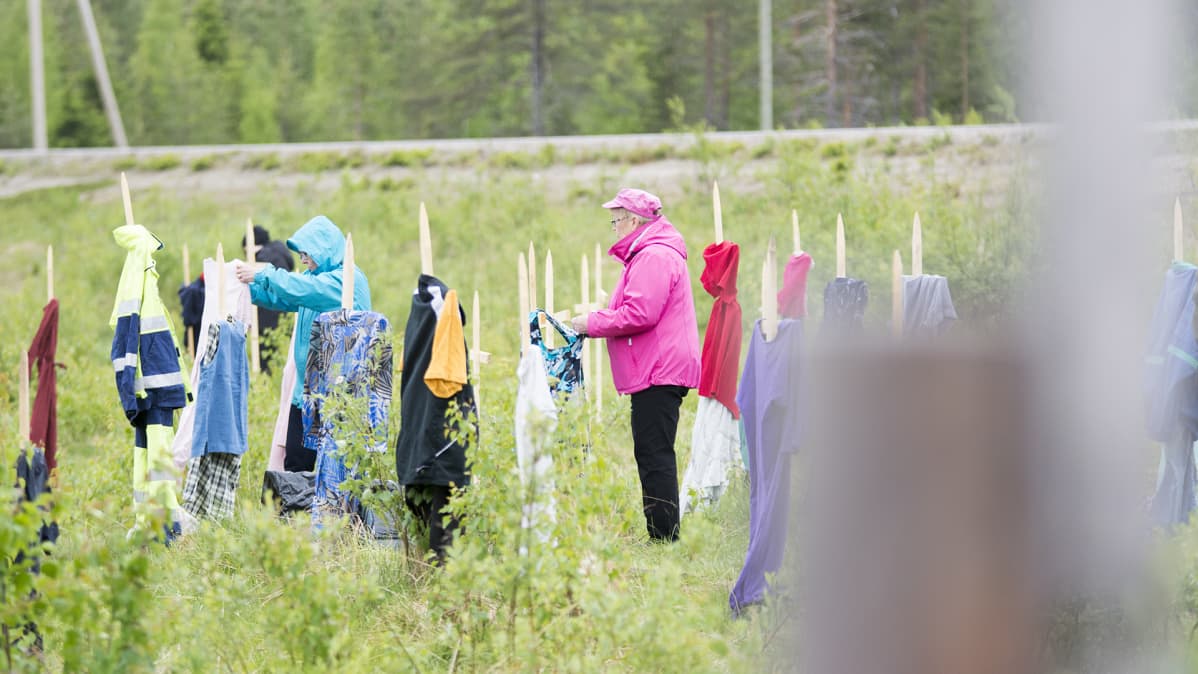 Naiset pukevat linnunpelättimiä.