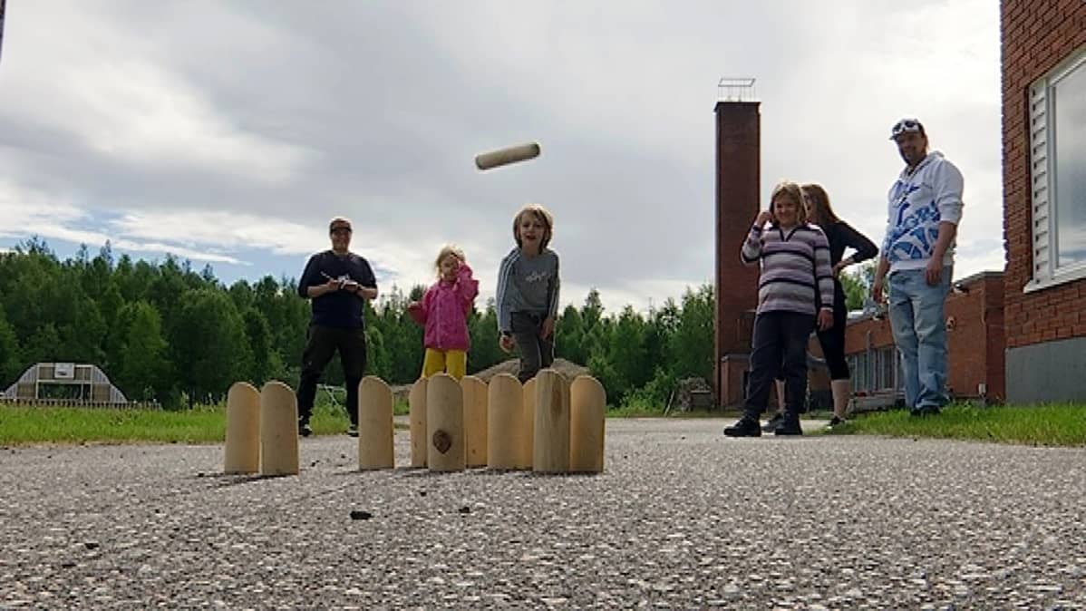 Juska heittää mölkkyä Meltauksen koulun pihalla
