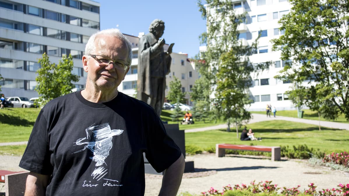 Mies seisoo Eino Leinon patsaan edustalla.
