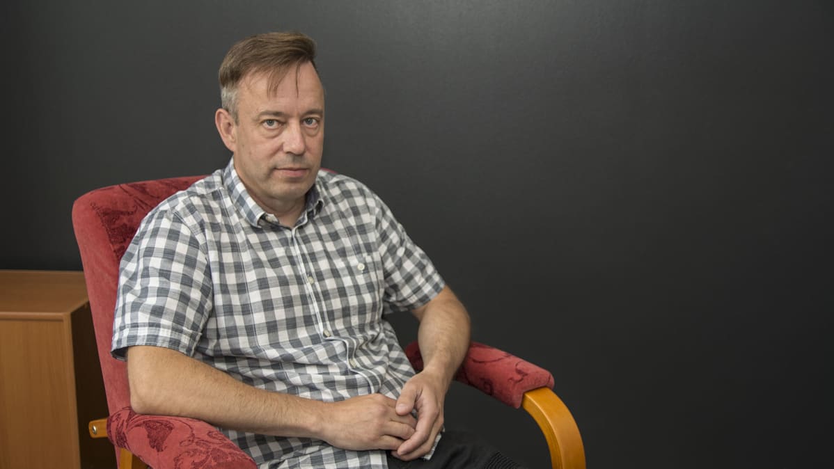 Esa Latvala istuu nojatuolilla ja katsoo kameraa.