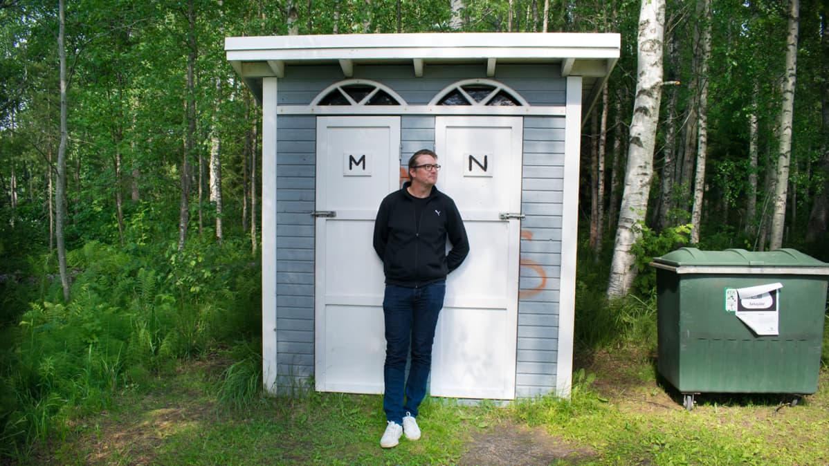 Timo J. Tuikka nojaa huussiin
