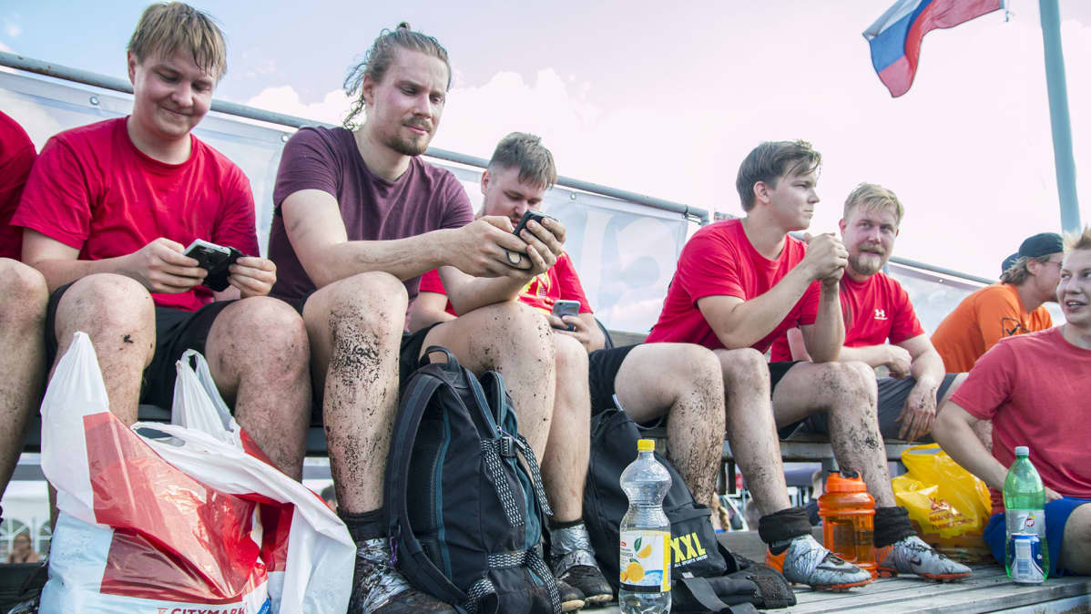 Suopotkupallon MM-kisat ihmisiä penkillä