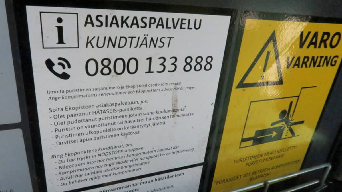 Asiakaspalvelutiedote kartonginkeräyspuristimen kyljessä