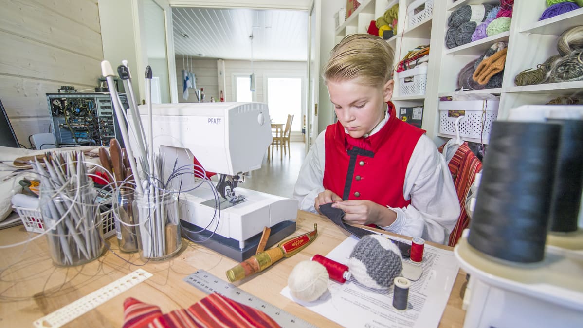 Jaakko Rikalainen ompelee kansallispukua.