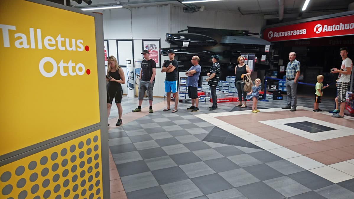 Asiakkaita jonottamassa pankkiautomaatille