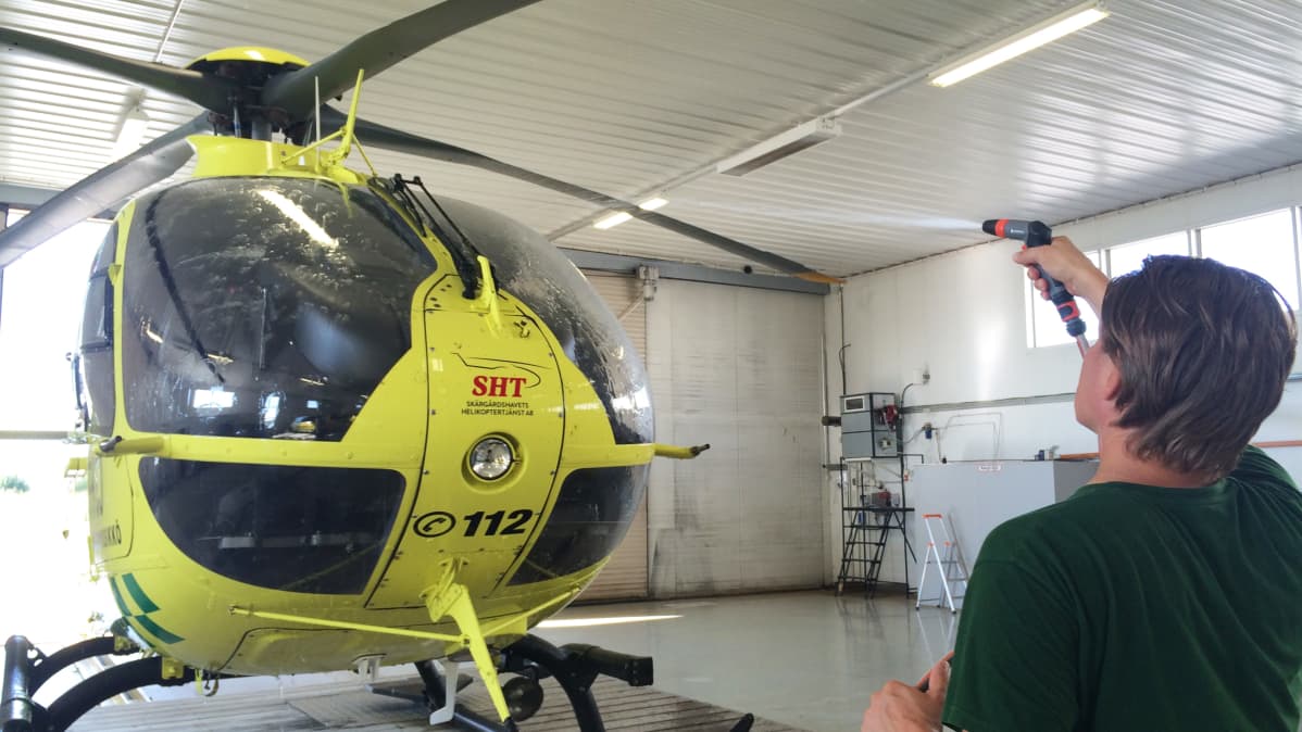 Lentäjä pesemässä helikopteria
