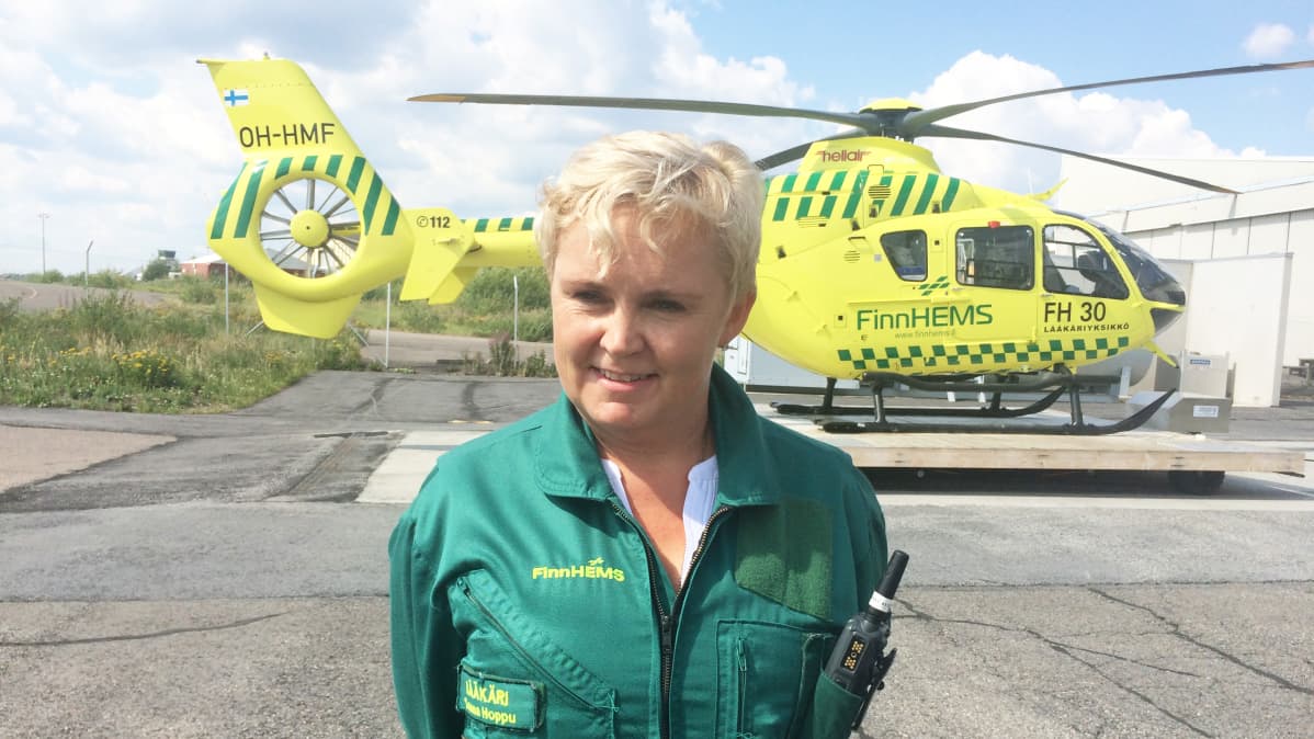 Lääkäri seisoo lääkärihelikopterin edessä