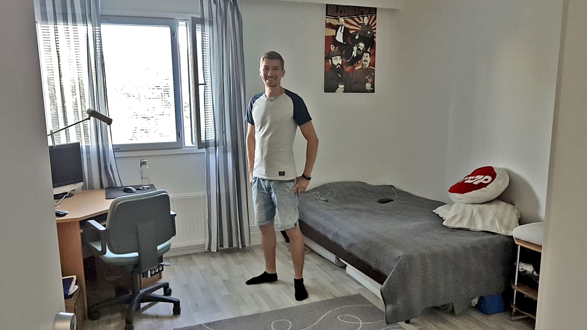 Teemu Sikanen seisoo huoneessaan soluasunnossa.