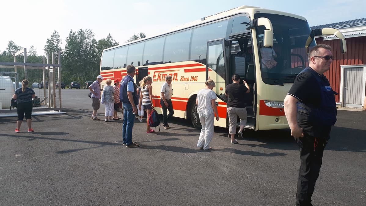 M/s Mässkärillä mukana olleita ihmisiä nousemassa bussiin.