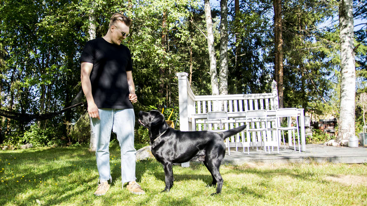 Joonas Sirviö labradorinnoutaja vierellään.