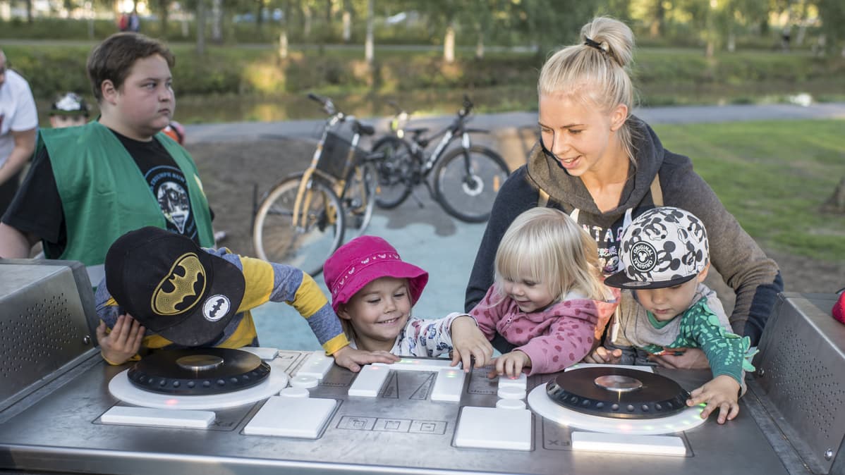 Äiti ja lapsia DJ-pöydän ääressä.
