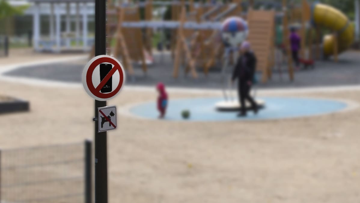 Kieltokyltti älypuhelimille leikkipuistoissa (kuvaa manipuloitu).