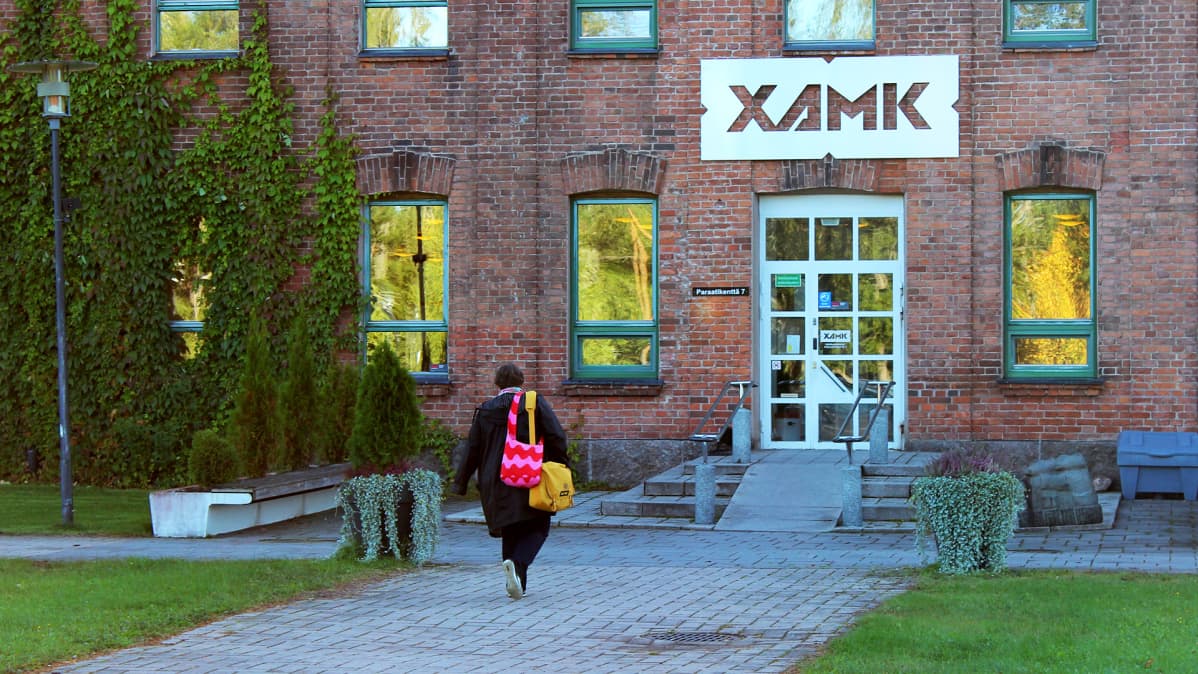 Nainen kävelee kohti Xamkin Kouvolan kampuksen pääovea