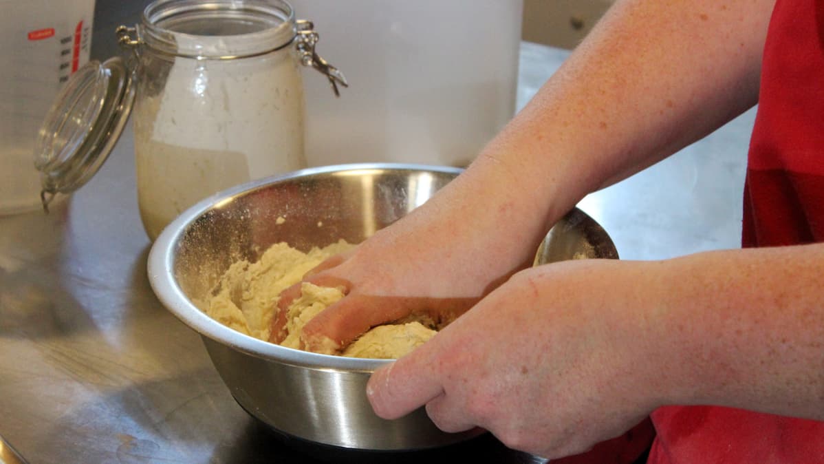 kädet vaivaavat taikinaa