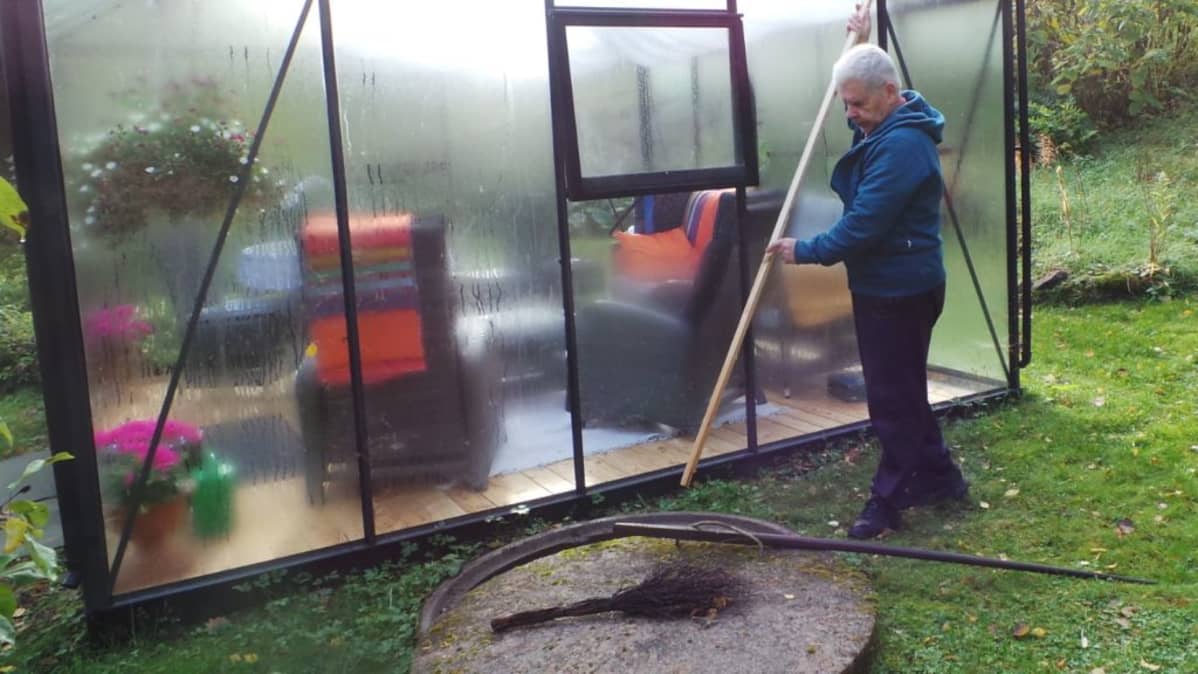 Sulo Järviluoma mittaa veden syvyyttä kaivossa.