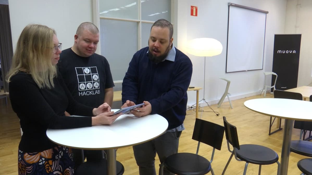 Järjestäjät Miia Lammi, Sami Olmari ja Sebastian Laitila tutkivat edelliskerralla kehitettyä mobiilisovellusta.