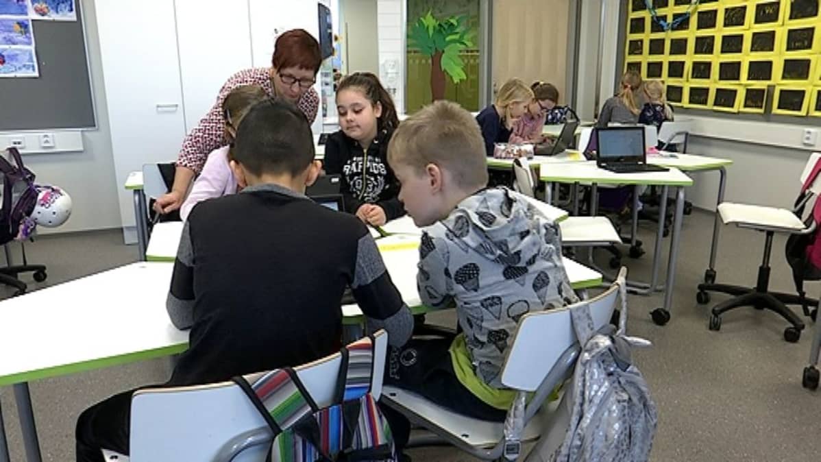 Opettaja ja oppilaita Kaarisillan koulussa