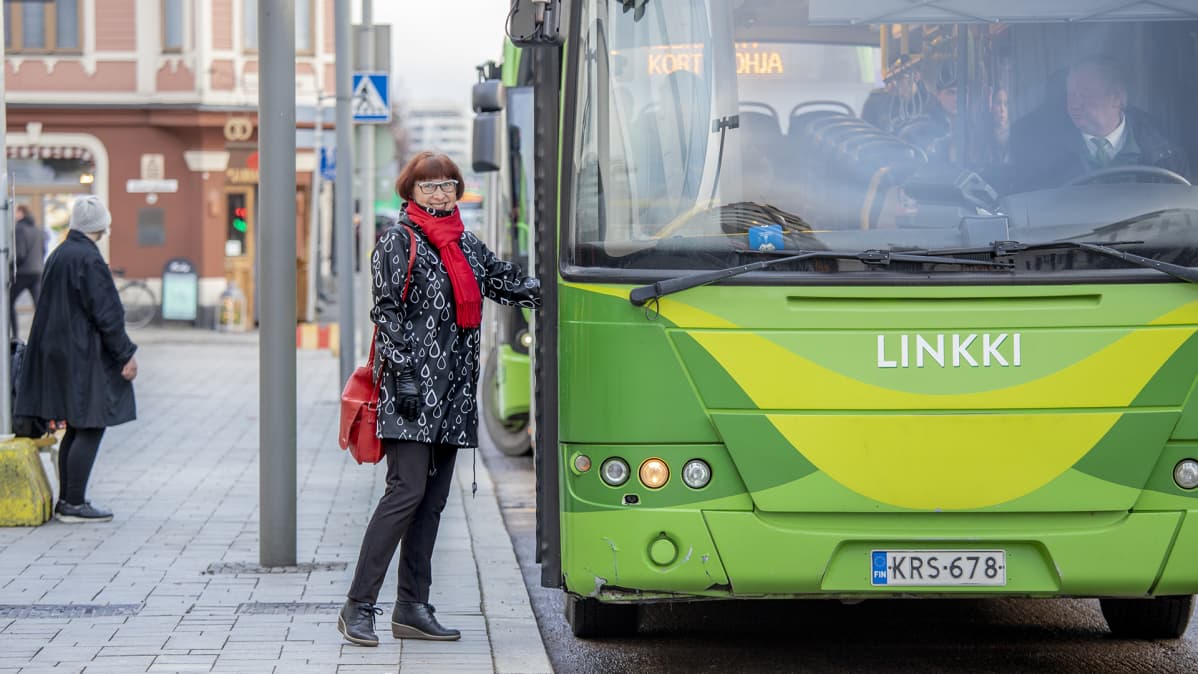 Nainen on astumassa linja-autoon.
