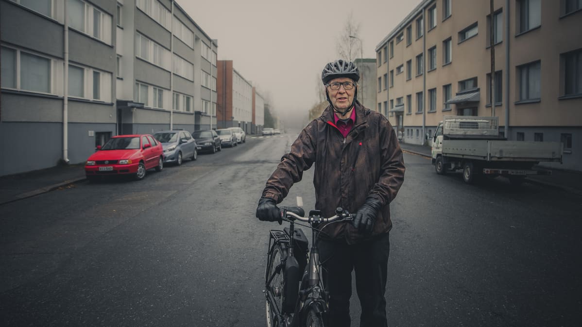 Mies pyöränsä kanssa