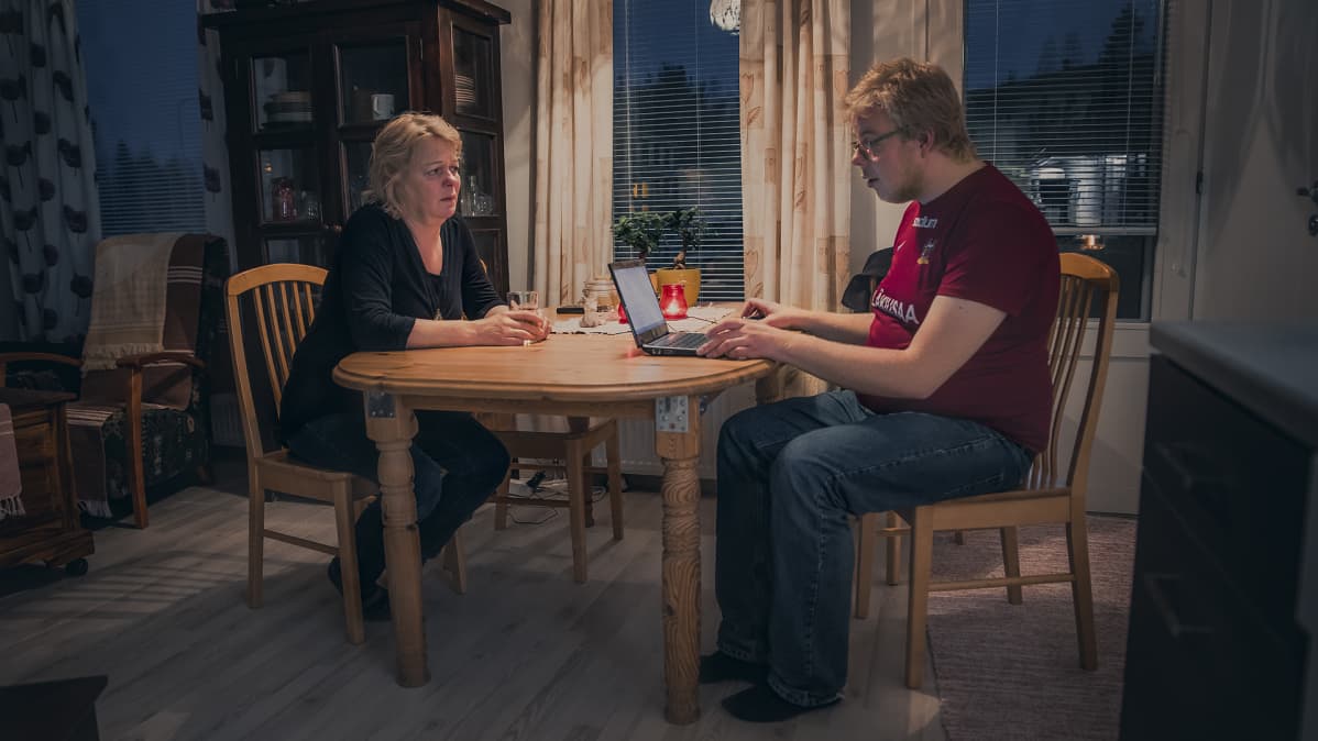 Konsta Pylkkänen ja äiti Tuula Pylkkänen tietokoneella keittiönpöydän ääressä.