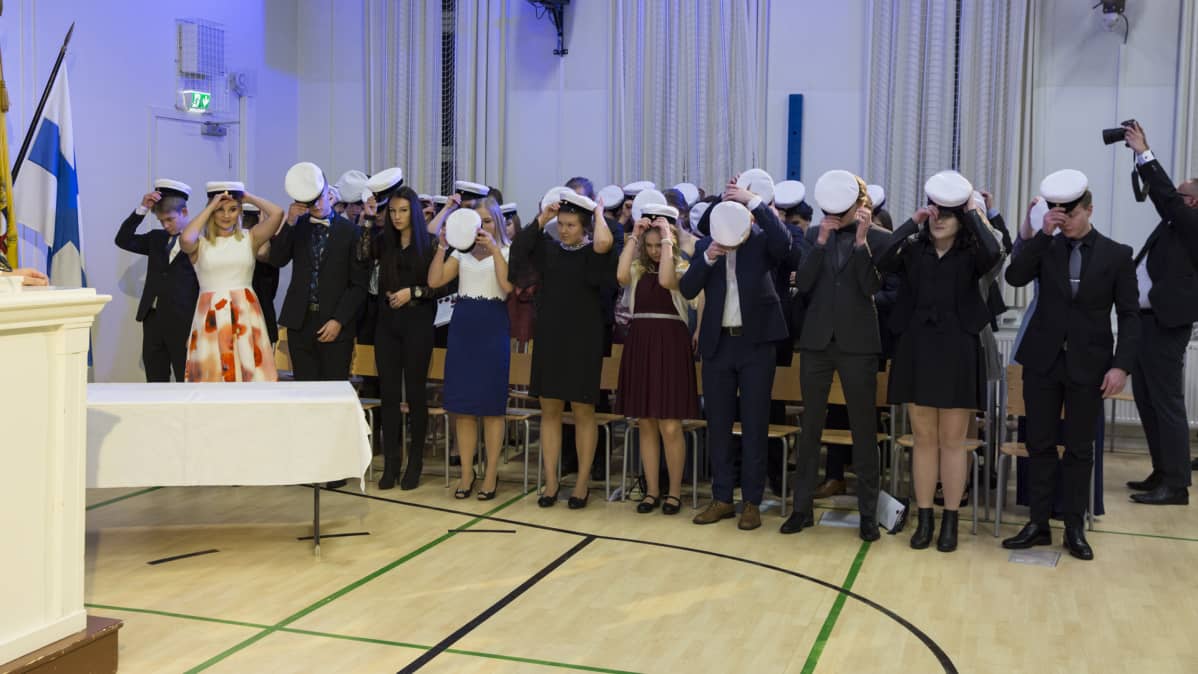 Uudet ylioppilaat laittavat valkolakit päähän