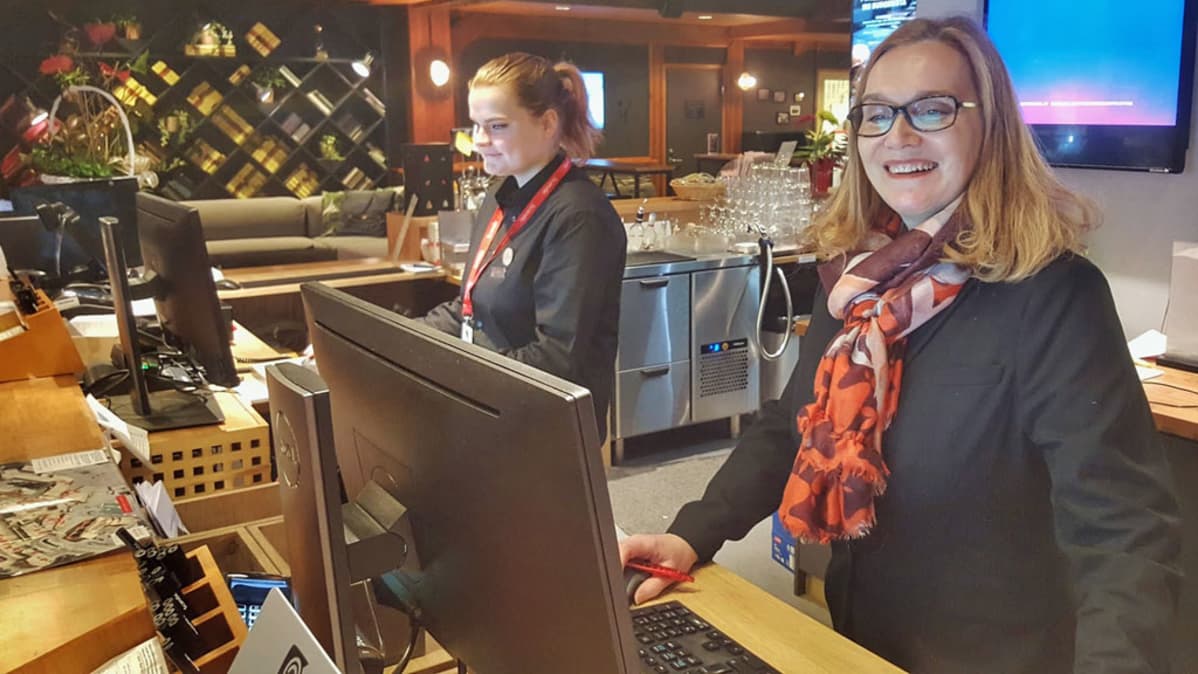 Kaksi hotellissa työskentelevää naista vastaanotossa.
