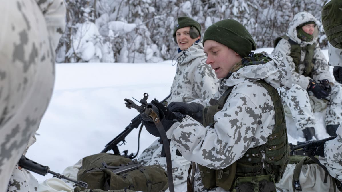 Varusmies huoltaa rynnäkkökivääriä talvisessa metsässä